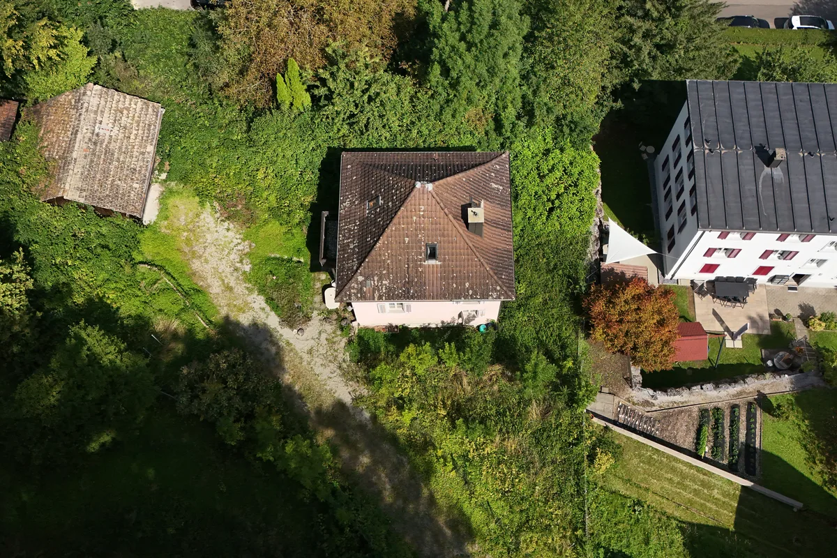 Man sieht ein Einfamilienhaus, ein Grundstück und einen Schopf von oben.